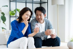 スマホをみてFacebook以外のデジタル遺品を考える中年夫婦